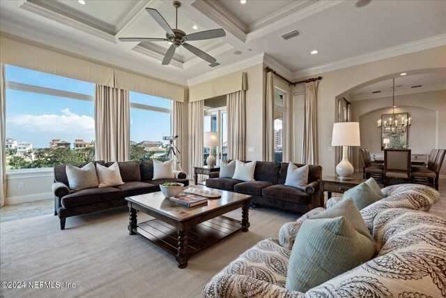 living room featuring light colored carpet, coffered ceiling, ceiling fan with notable chandelier, and ornamental molding