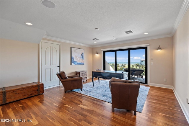 living room with ornamental molding, hardwood / wood-style floors, and a textured ceiling