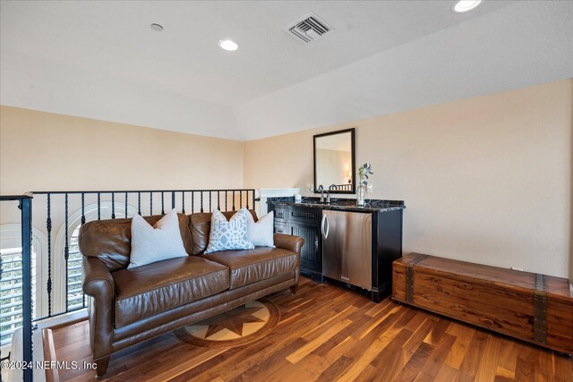 sitting room featuring dark hardwood / wood-style flooring, sink, and vaulted ceiling