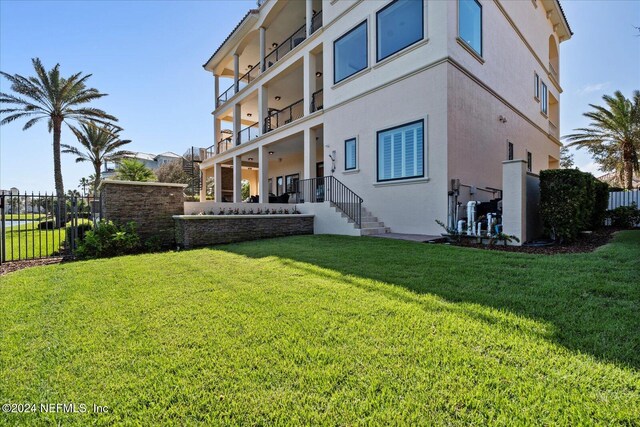 exterior space featuring a lawn and a balcony