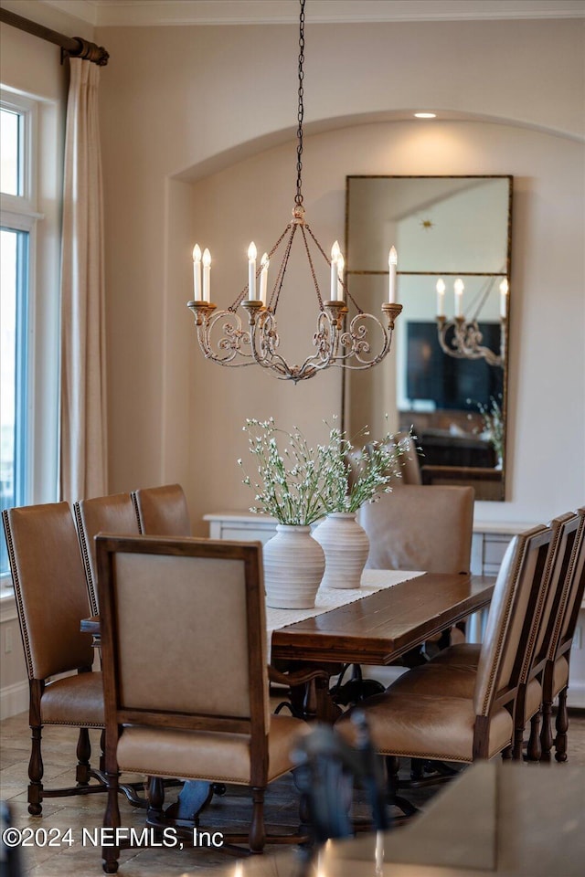 dining area with ornamental molding and an inviting chandelier