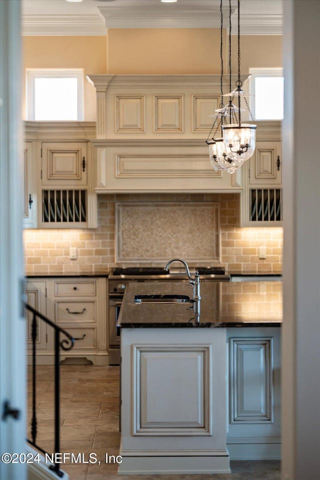 kitchen with decorative backsplash, pendant lighting, and cream cabinets