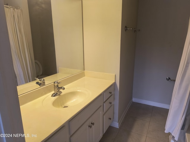 bathroom with toilet, vanity, and tile patterned floors