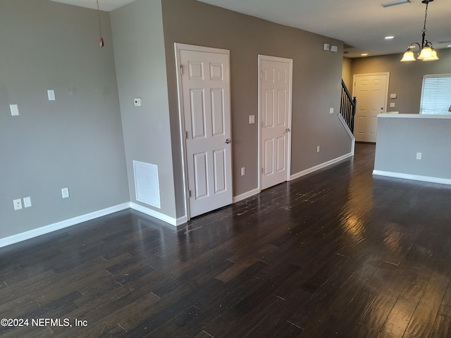 unfurnished room with dark hardwood / wood-style flooring and a chandelier