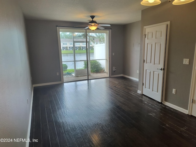 unfurnished room featuring ceiling fan, a textured ceiling, and dark hardwood / wood-style flooring