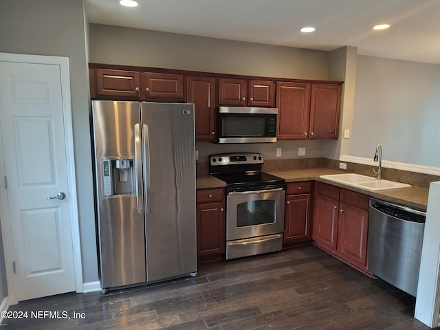 kitchen with dark wood-type flooring, appliances with stainless steel finishes, and sink