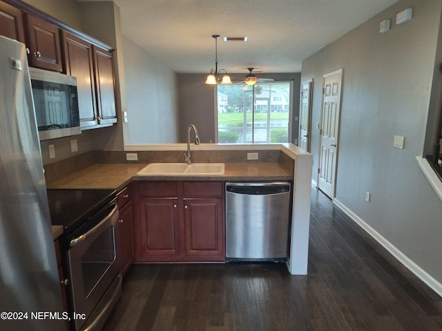 kitchen featuring kitchen peninsula, appliances with stainless steel finishes, sink, and dark hardwood / wood-style floors