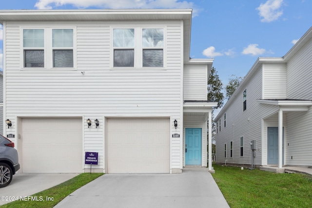 view of front of property featuring a garage and a front lawn