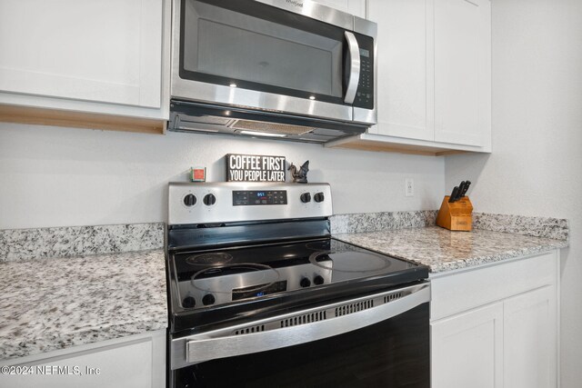 kitchen with white cabinets and appliances with stainless steel finishes