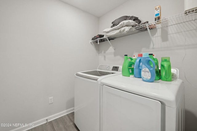 laundry area with hardwood / wood-style floors and separate washer and dryer