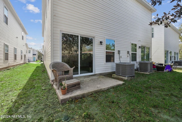 rear view of house featuring a yard, a patio, and central AC