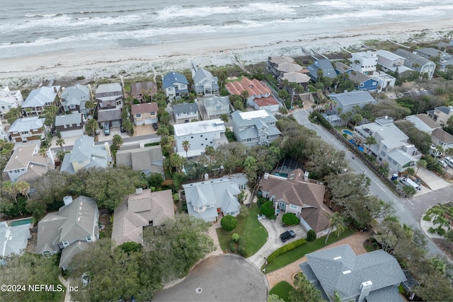 drone / aerial view with a water view, a residential view, and a beach view