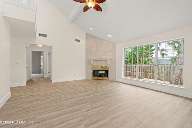 unfurnished living room featuring a large fireplace, visible vents, a ceiling fan, light wood-style flooring, and beam ceiling