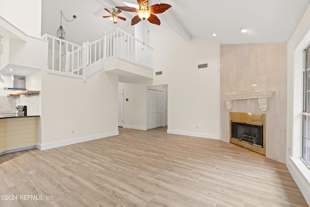 unfurnished living room featuring visible vents, baseboards, a ceiling fan, light wood-style floors, and a fireplace