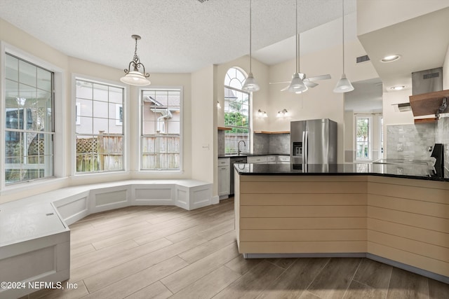 kitchen featuring stainless steel appliances, hanging light fixtures, dark countertops, and open shelves