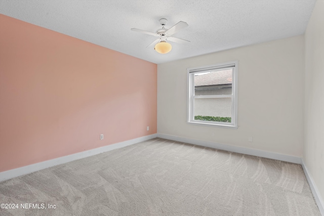 unfurnished room with a ceiling fan, baseboards, a textured ceiling, and light colored carpet