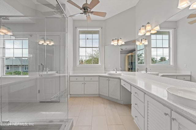 full bath with double vanity, a stall shower, a sink, and a ceiling fan