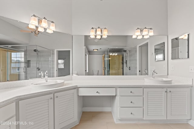 bathroom featuring a stall shower, tile patterned floors, a sink, and double vanity