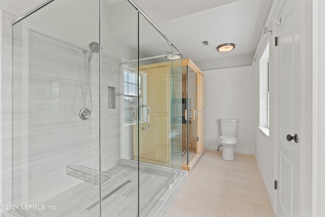 full bathroom featuring toilet, a shower stall, and baseboards