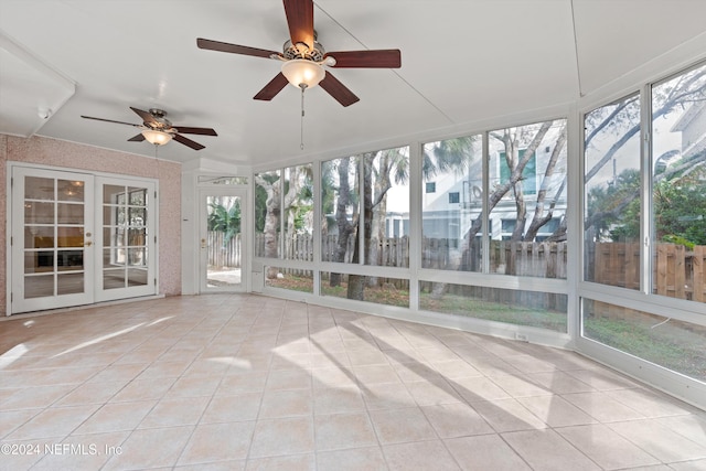 unfurnished sunroom featuring ceiling fan and french doors