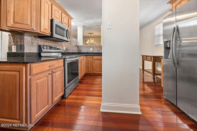 kitchen with a textured ceiling, tasteful backsplash, stainless steel appliances, and dark hardwood / wood-style floors