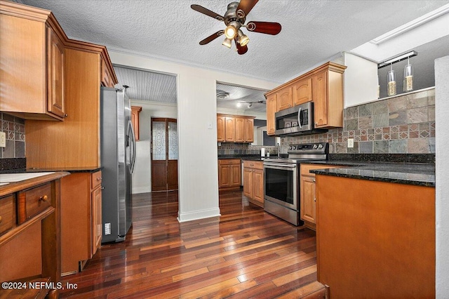 kitchen featuring backsplash, crown molding, dark hardwood / wood-style floors, a textured ceiling, and appliances with stainless steel finishes