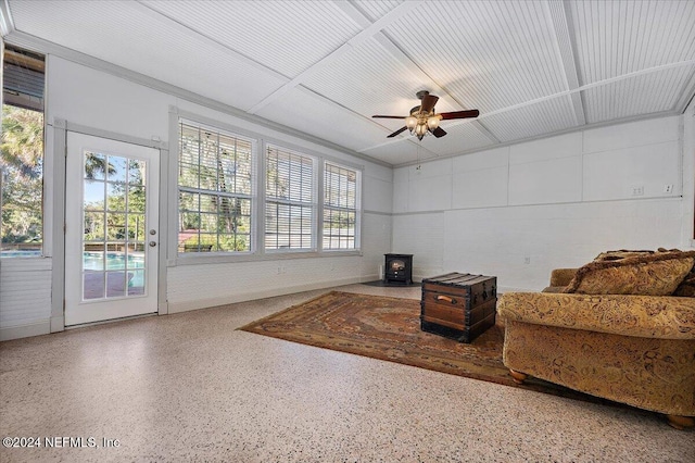 interior space featuring ceiling fan and a wood stove