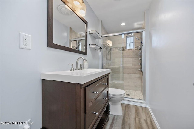 bathroom with toilet, vanity, an enclosed shower, and hardwood / wood-style flooring