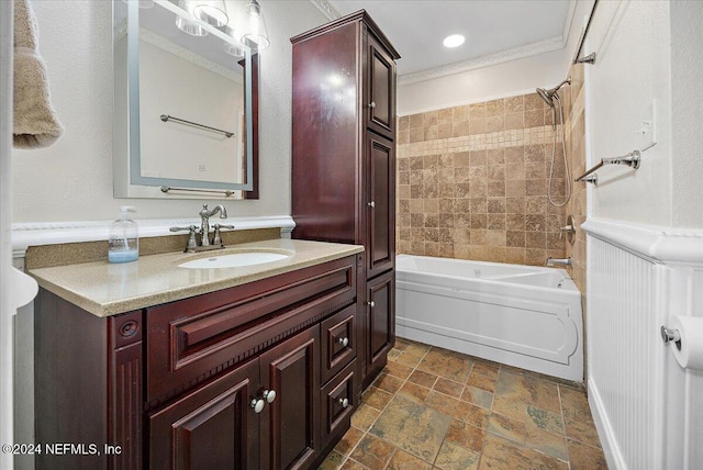 bathroom with crown molding, vanity, and tiled shower / bath combo