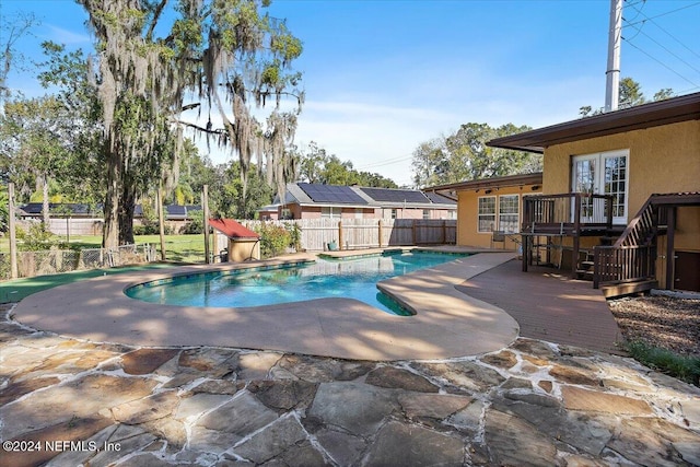 view of swimming pool with a wooden deck and a patio