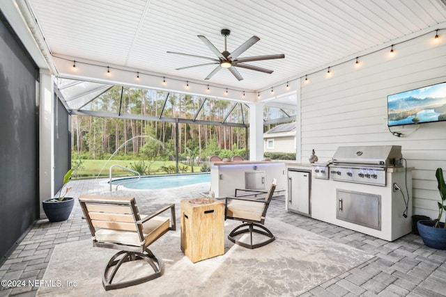 view of patio featuring ceiling fan, glass enclosure, area for grilling, and grilling area