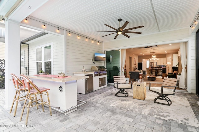 view of patio with area for grilling, a grill, and an outdoor bar