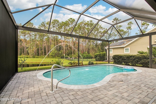 view of pool with pool water feature, glass enclosure, and a patio