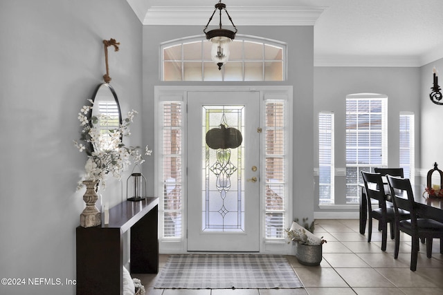 tiled foyer entrance featuring crown molding