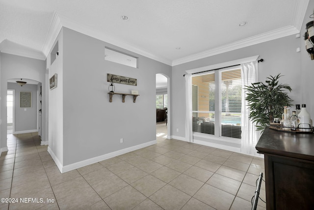 tiled spare room with a textured ceiling and crown molding