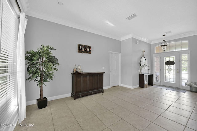 tiled foyer entrance with a textured ceiling and crown molding