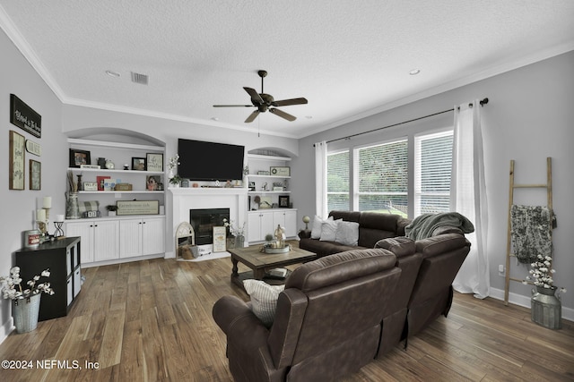 living room featuring a textured ceiling, ceiling fan, crown molding, and dark wood-type flooring