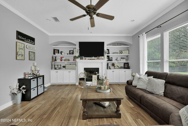 living room featuring a textured ceiling, light hardwood / wood-style flooring, ceiling fan, and ornamental molding