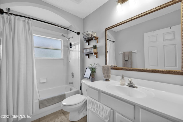 full bathroom featuring tile patterned floors, shower / bathtub combination with curtain, vanity, and toilet