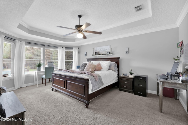 bedroom with light colored carpet, ceiling fan, crown molding, and a tray ceiling