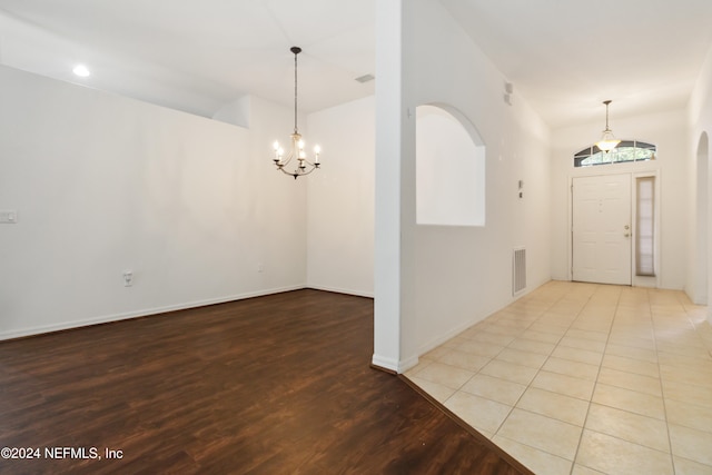 tiled entrance foyer featuring a notable chandelier