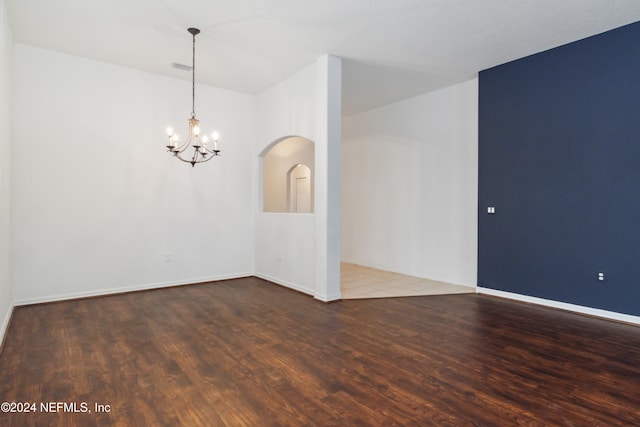 empty room featuring dark hardwood / wood-style floors and a chandelier