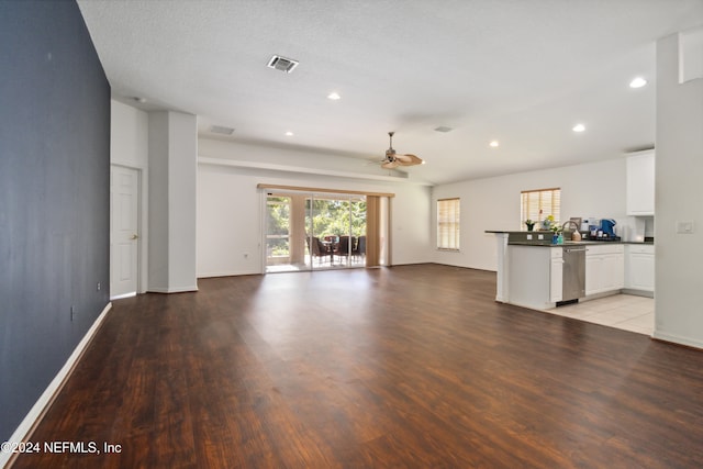 unfurnished living room with ceiling fan, a textured ceiling, and light hardwood / wood-style flooring