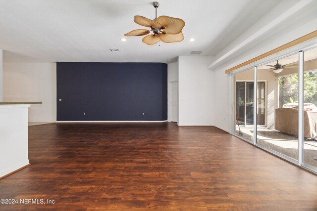 unfurnished living room with dark hardwood / wood-style flooring and ceiling fan