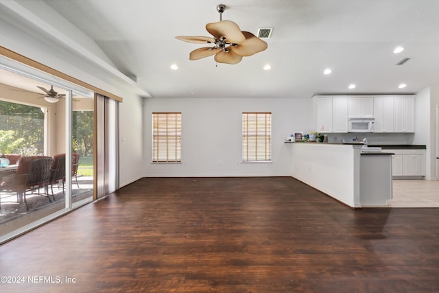 unfurnished living room with ceiling fan, dark wood-type flooring, and vaulted ceiling