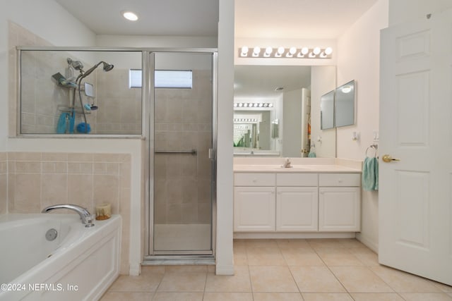 bathroom with tile patterned flooring, vanity, and plus walk in shower