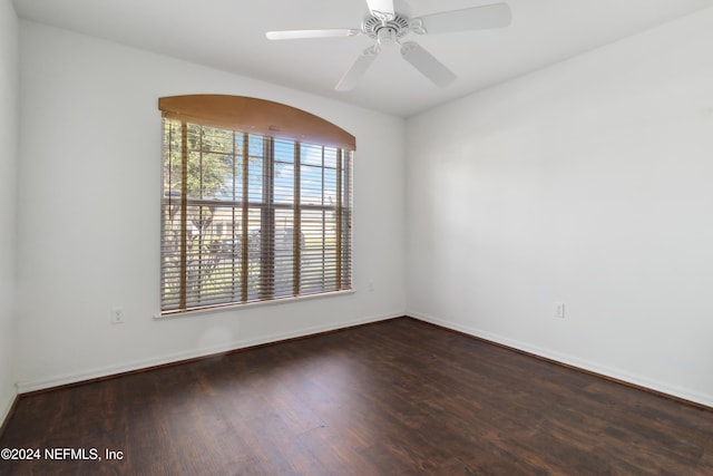 empty room featuring wood finished floors, baseboards, and ceiling fan