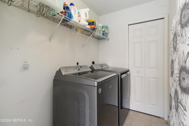 laundry room with washing machine and clothes dryer and light tile patterned flooring