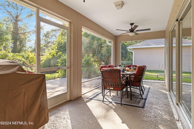 sunroom with outdoor dining space and a ceiling fan