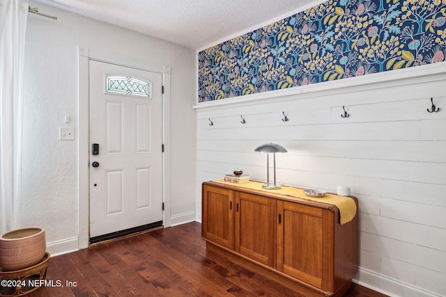 mudroom with a textured ceiling and dark wood-type flooring